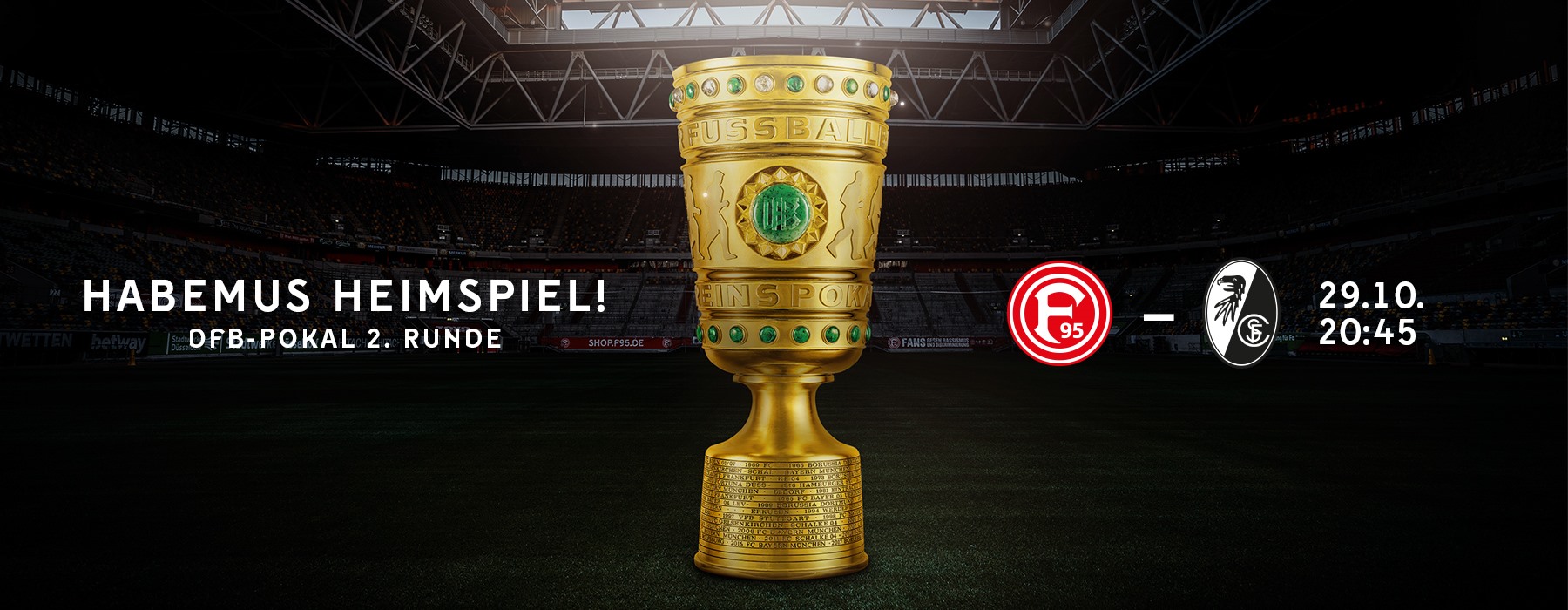 Spielpaarung F95 gegen SC Freiburg - Der Spruch "Habemus Heimspiel" mit dem DFB-Pokal und dem Stadion im Hintergrund
